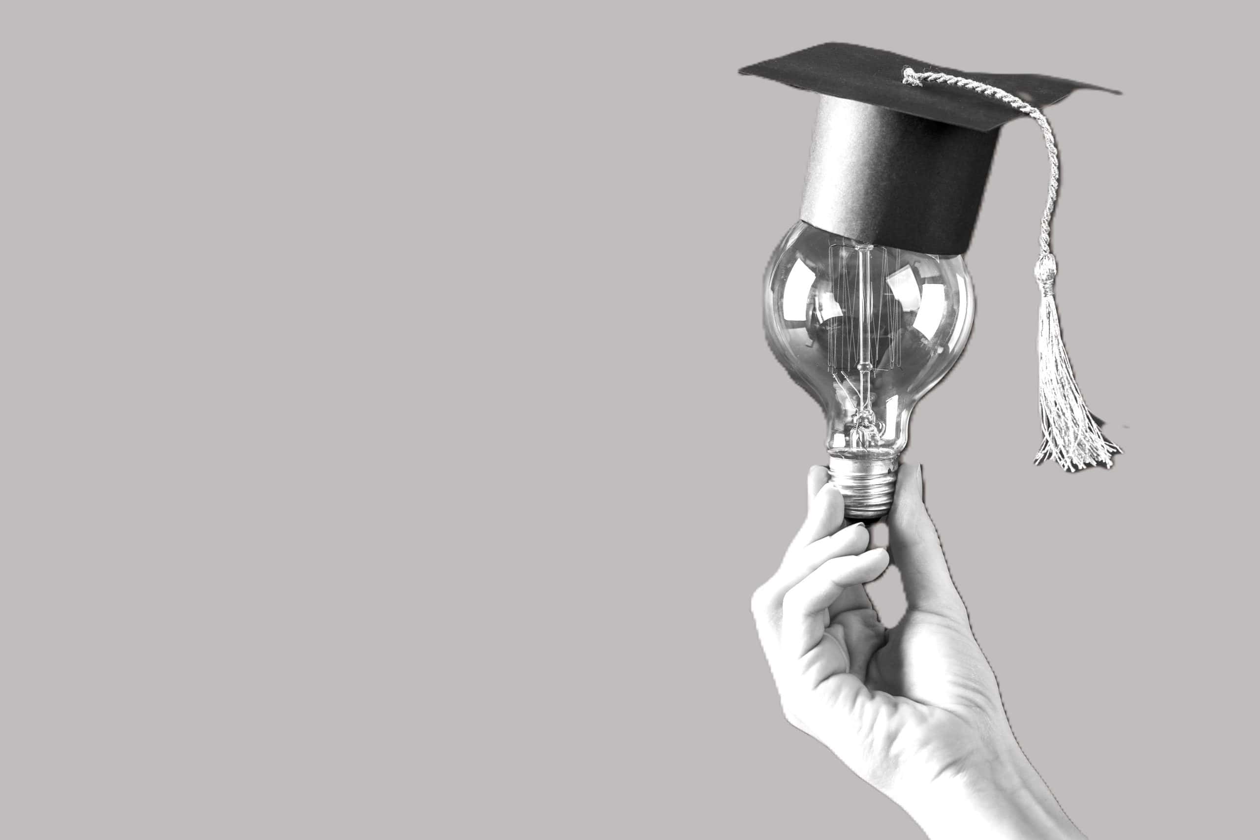 hand met lamp met studeerhoedje op